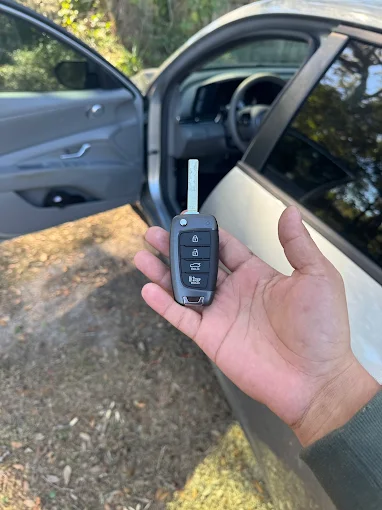 A technician from Local Locksmith Pros LLC presenting a new car key fob after successfully completing an Automotive Broken Key Extraction and key replacement.
