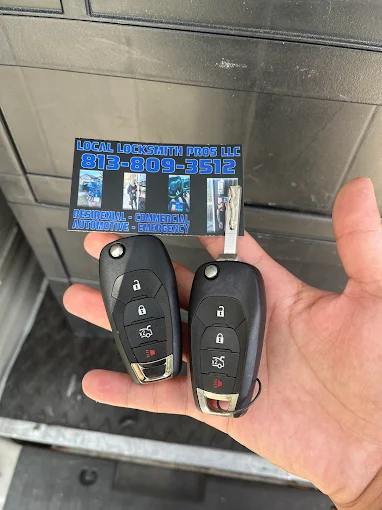 A technician from Local Locksmith Pros LLC displaying two new car key fobs, demonstrating the successful resolution following an Automotive Broken Key Extraction.