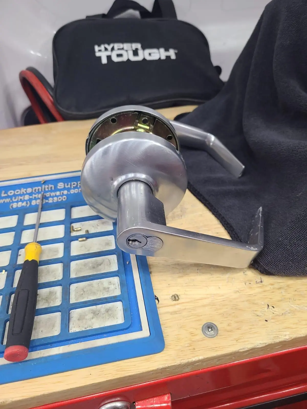 A heavy-duty lever door handle on a locksmith's pinning tray, ready for a professional Residential Lock Rekeying service by Local Locksmith Pros LLC.