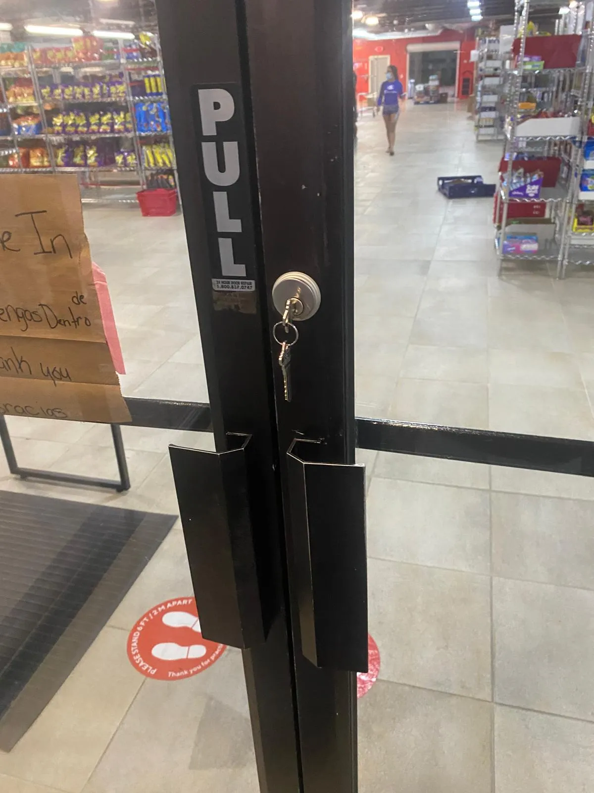 A glass storefront door with a key in the lock, showcasing a typical lock and key service provided by a Commercial Locksmith from Local Locksmith Pros LLC.