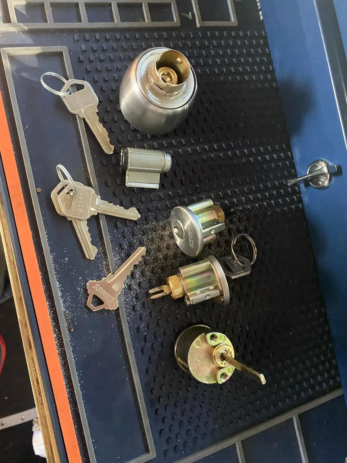 Close-up of lock cylinders and keys laid out for a professional Residential Lock Rekeying service by Local Locksmith Pros LLC.