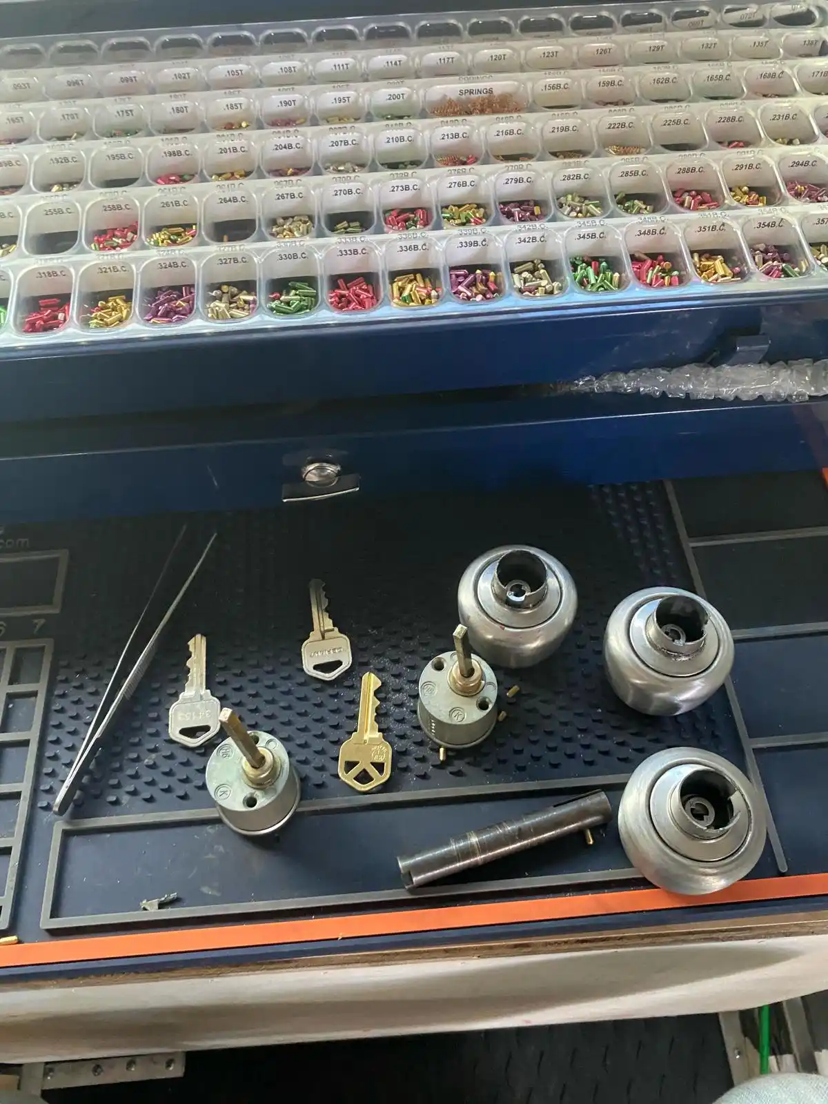 A Residential Locksmith workbench for Local Locksmith Pros LLC, set up with a master pinning kit, lock cylinders, keys, and re-keying tools.